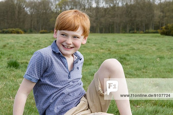 Portrait of boy sitting in field