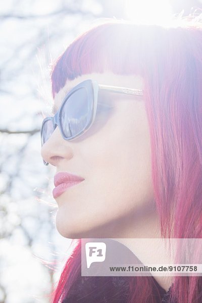 Nahaufnahme Porträt einer jungen Frau mit rosa Haaren und Sonnenbrille