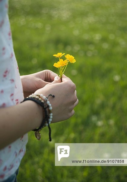 Young woman holding yellow flowers  close up