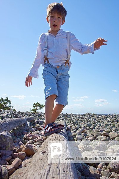 Junge beim Balancieren am Strand