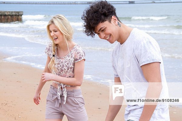 Glückliches junges Paar beim Strandspaziergang