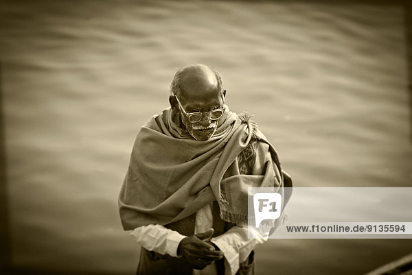 An elderly man along the banks of the Ganges River  Varanasi  India