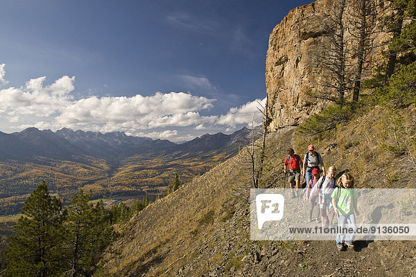 Young family hiking on Castle Mountain Trail in autumn  Fernie  BC  Canada.