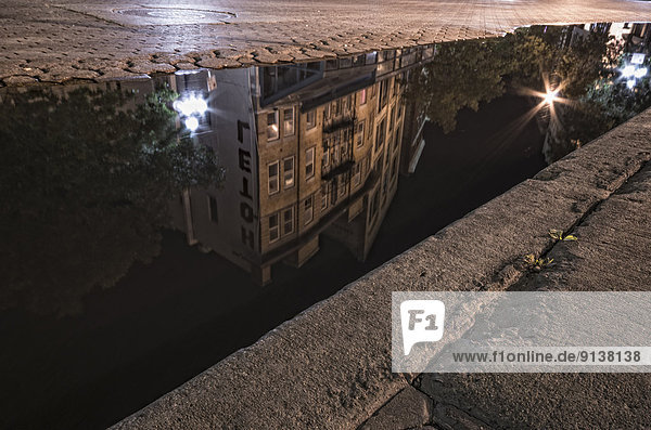 Reflection of an old heritage building in a puddle in Winnipeg's Exchange District. Manitoba.