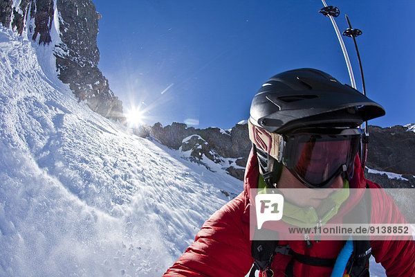 A male splitboarder captures a self portait pov while descending a steep couloir on Mt French  Peter Lougheed Provincial Park  Kananaskis  AB