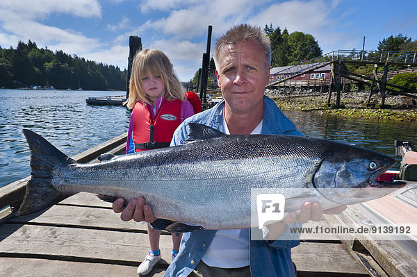 Proud fisherman with 24 pound chinook salmon and unimpressed daughter.