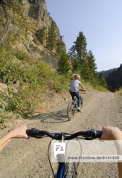 Young girls ride their bikes near the Princeton Hoodoos on the KVR Trail in the Similkameen region of British Columbia  Canada