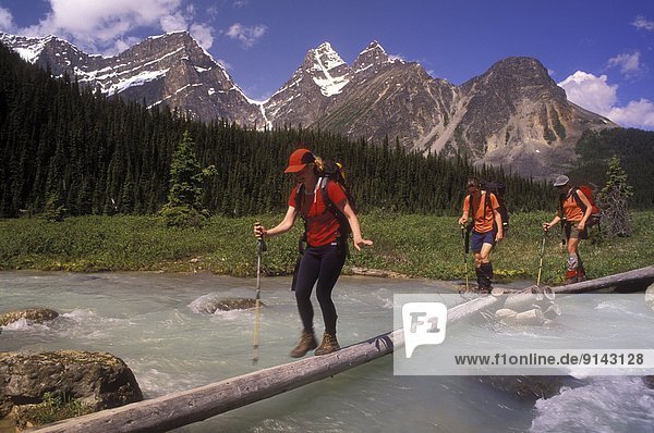 'Tonquin Valley; 3 women crossing Eremite Creek  Jasper National Park  Alberta  Canada'