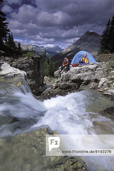 Couple camping near backcountry waterfall  eastern British Columbia  Canada