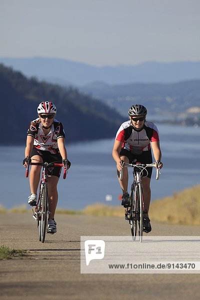 Teenage females cyclists over looking Kalamalka Provincial Park  near Vernon  Okanagan  British Columbia  Canada