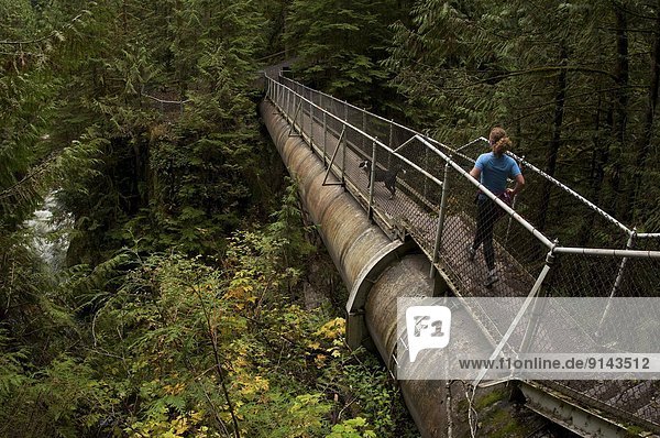 Woman trail running on the Capilano Pacific Trail  Capilano River Regional Park  North Vancouver  British Columbia  Canada