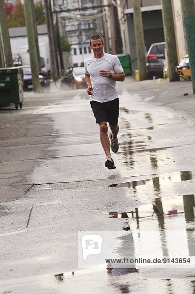 Man running on sidewalk in downtown Vancouver  British Columbia  Canada
