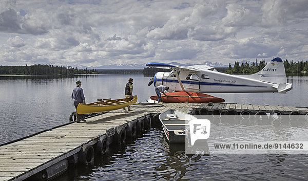 Loading canoes onto docked float plane  Coast Mountains  British Columbia  Canada