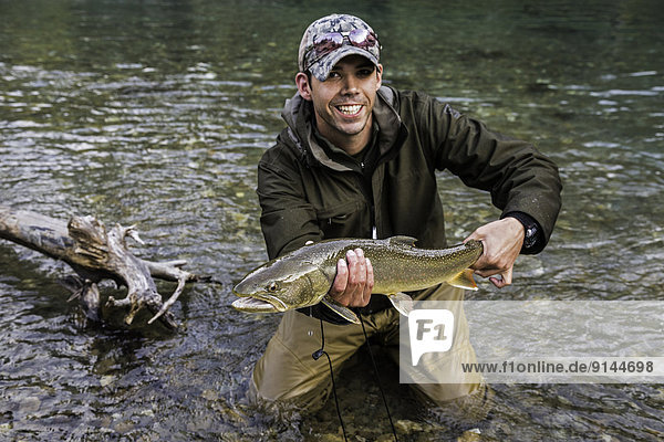 Fihserman with bull trout (Salvelinus confluentus)  Mitchell River  Cariboo Mountains  British Columbia  Canada