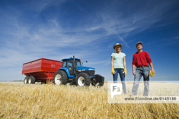 stehend  Getreide  Menschlicher Vater  Traktor  ernten  Bauernhof  Hof  Höfe  frontal  Hafer  Mädchen  Kanada  Manitoba