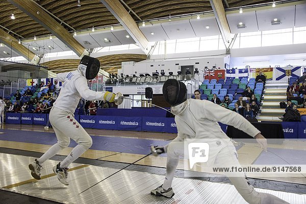Marc-Andre Leblanc (CAN) scoring point on the New Zealand fencer at Vancouver Grand Prix of Men's Epee 2013 at Richmond Olympic Oval. Richmond  British Columbia Canada