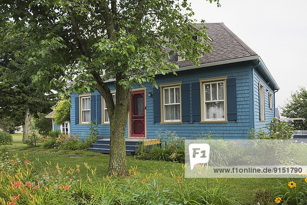 Old blue cottage style residential house in summer  Quebec  Canada