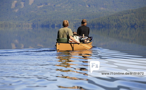 a couple canoeing on Watchan Lake  British Columbia  Canada  Darrel Giesbrecht