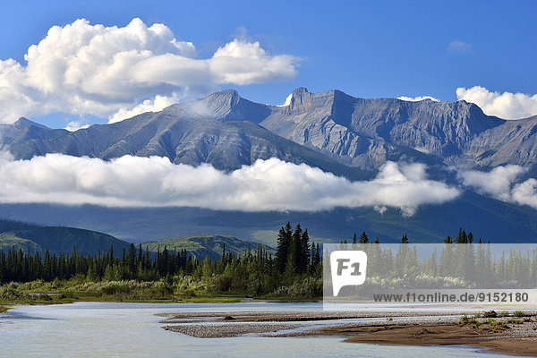 A horizontal image of the Athabasca river and the Canadian rocky mountains in Jasper National Park with low hanging cloud formations.