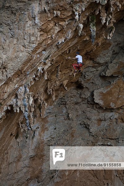 A male climber falls while climbing the limestone route Morgan 7b+  Sitkati Cave  Kalymnos  Greece