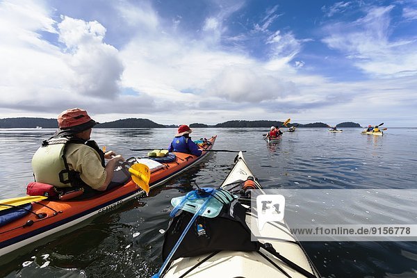 A group of kayakers transits Thiepval Channel located within the Broken Island Group  Barkley Sound  Vancouver Island  British Columbia  Canada
