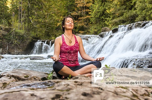 Außenaufnahme  Meditation  frontal  Wasserfall  Yoga  Kanada  freie Natur  Pose