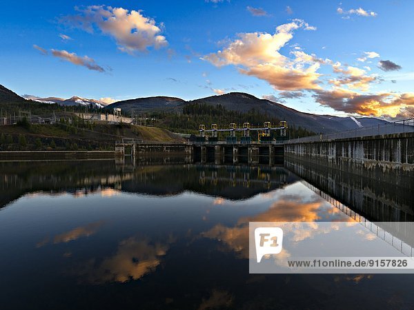 Reflection of the Kootenay Dam and peaks of the Bonnington Range at sunset  South Slocan BC.