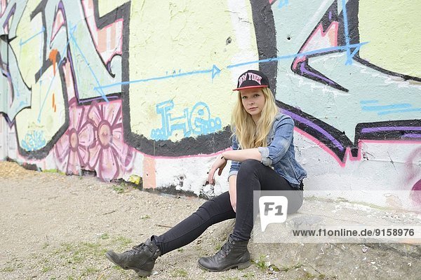 Junge Frau an einer Graffitiwand,  Nürnberg,  Bayern,  Deutschland,  Europa