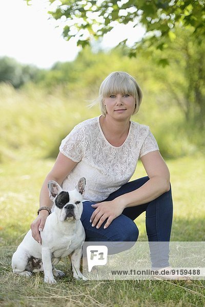 Frau mit einer sieben Monate alten Französischen Bulldogge