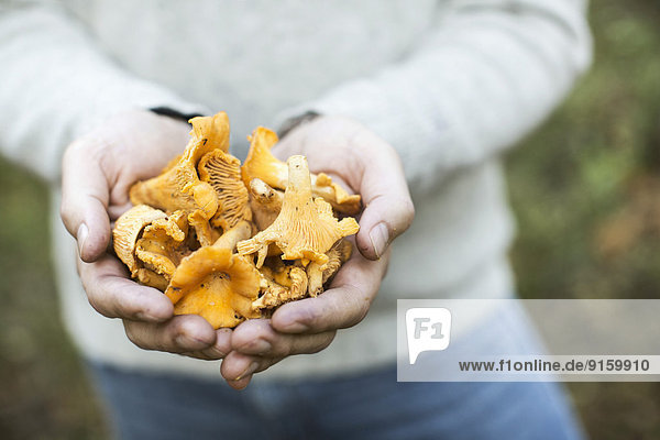 Mittelteil des Mannes mit Pilzen im Freien