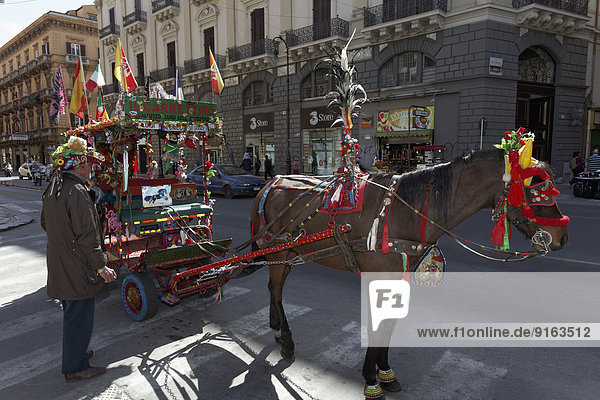 Bunt dekorierter sizilianischer Pferdekarren an der Via Roma  Kutscher wartet auf Touristen  Carretto siciliano  Palermo  Provinz Palermo  Sizilien  Italien