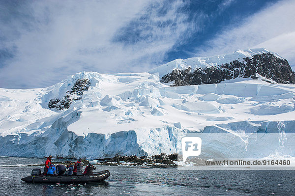 Tourists in a zodiac in front of glaciers and icebergs  Mikkelsen Islands  Antarctica