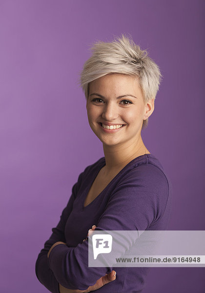 Blonde Frau vor violettem Hintergrund  Porträt