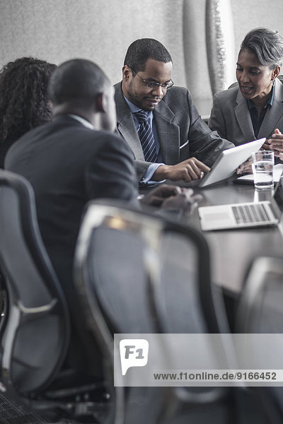 Business people using digital tablet in meeting