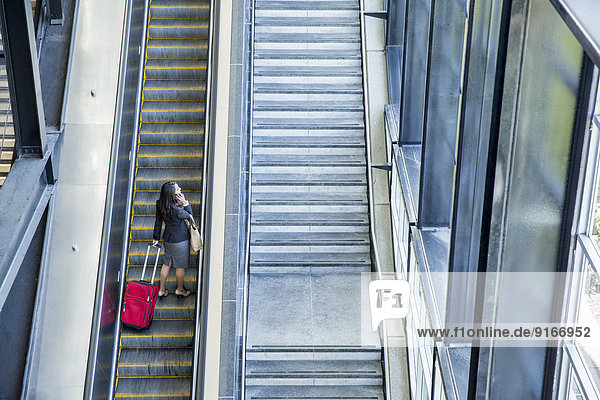 Businesswomen riding escalator