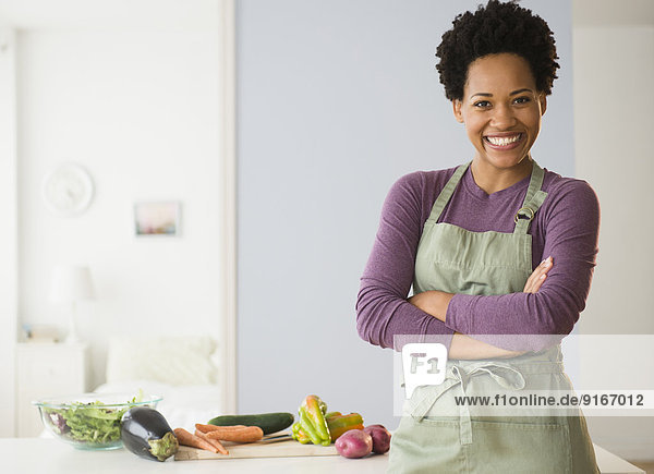 Portrait of black woman cooking in kitchen