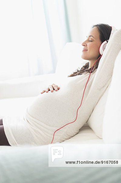 Frau zuhören Kopfhörer Hispanier Schwangerschaft