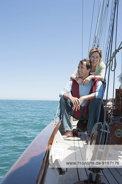 Caucasian couple relaxing on sailboat