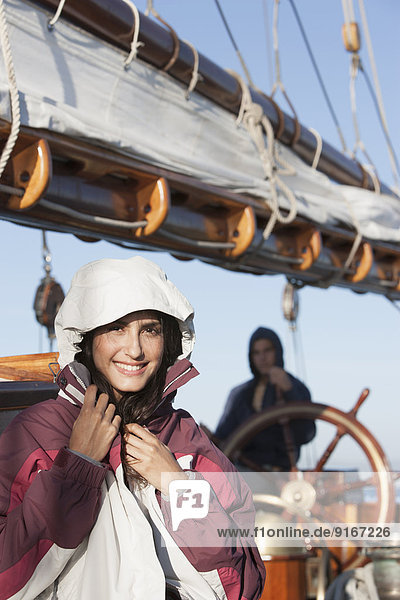 Caucasian woman wearing jacket on sailboat