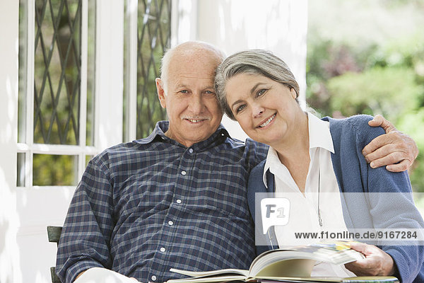 Senior Caucasian couple reading outdoors