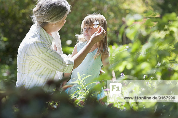 Grandmother and granddaughter picking flowers