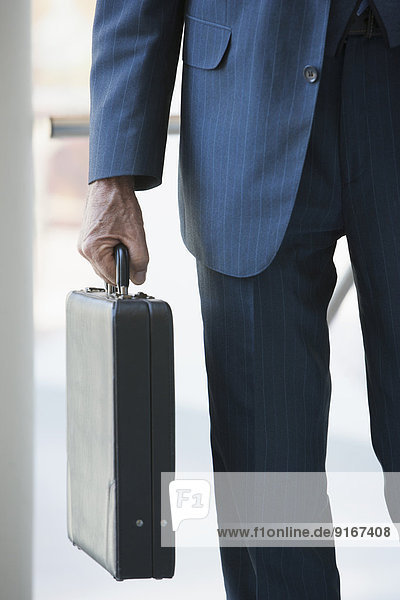 Senior Caucasian businessman carrying briefcase