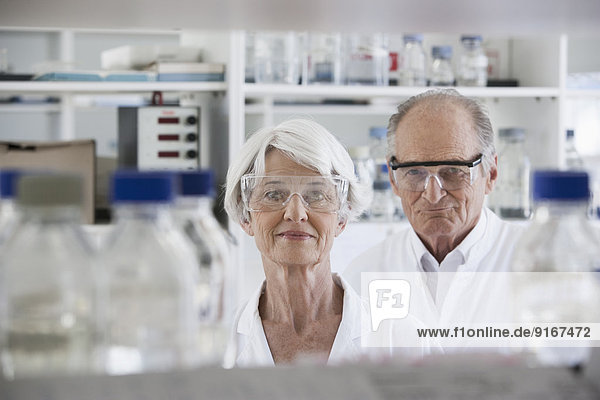 Senior Caucasian scientists smiling in lab