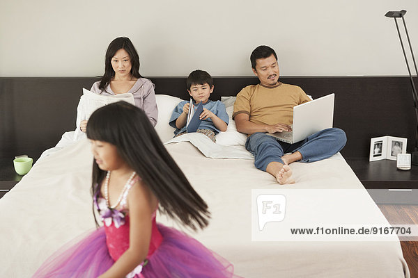 Family relaxing together in bedroom