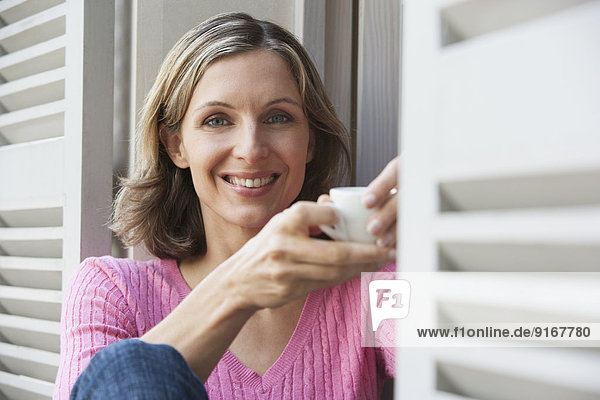 Woman having cup of coffee outdoors
