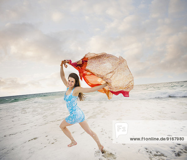 Caucasian woman playing on beach