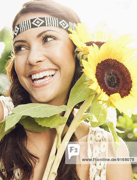 Hispanic woman holding sunflowers