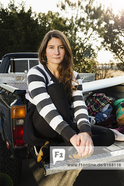 Woman sitting in truck bed