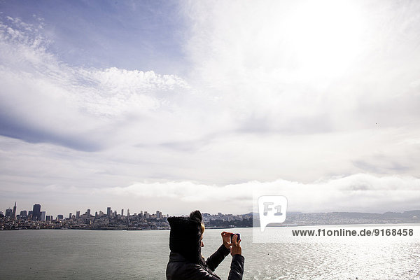 Woman taking picture of city skyline  San Francisco  California  United States