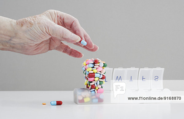 Senior Caucasian man stacking pills in pill box
